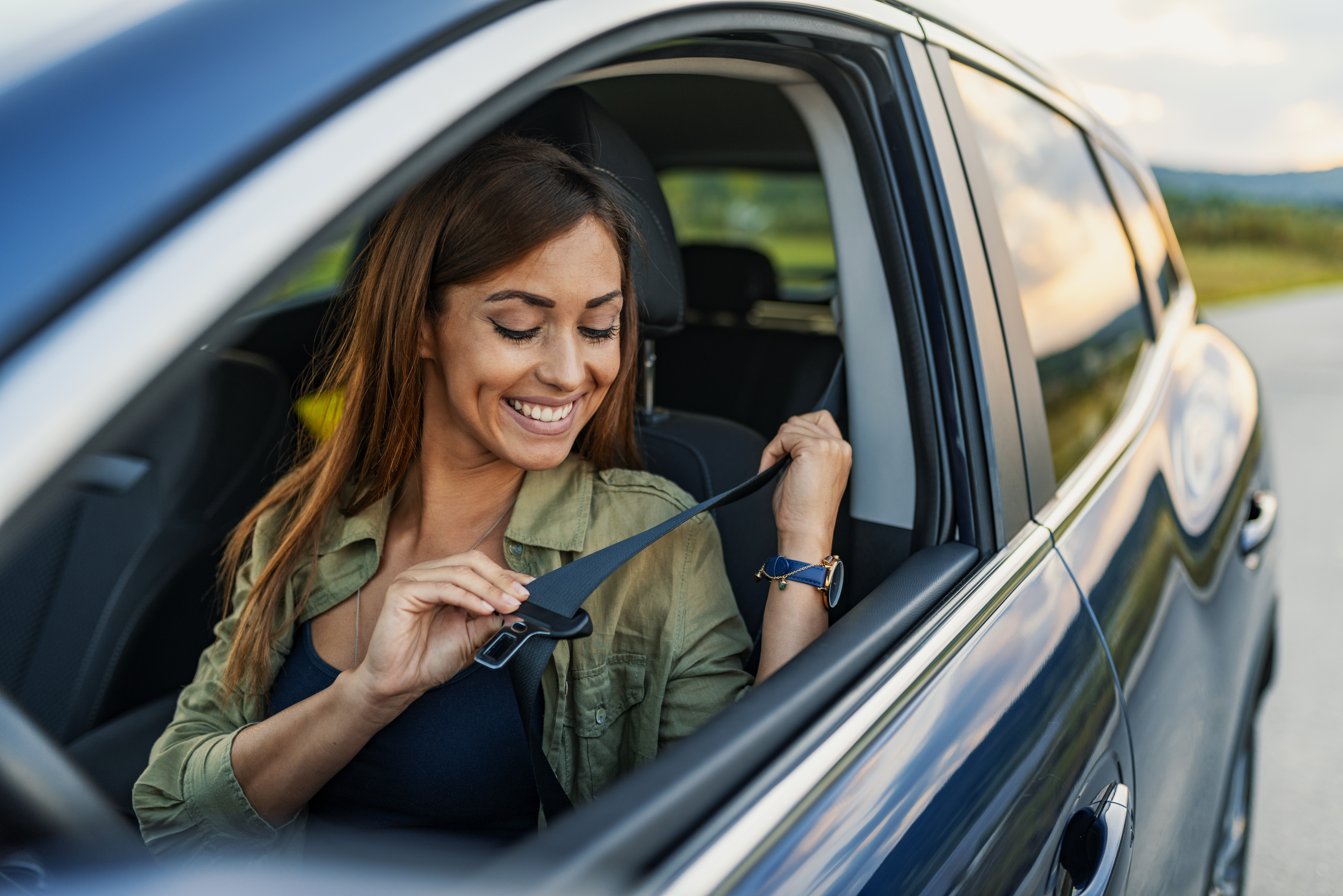 Frau im Auto schnallt sich mit Gurt an