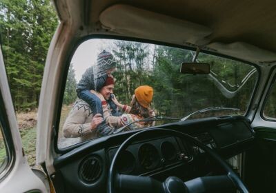 Familie im Herbst im Wald mit Blick durch Autoscheibe