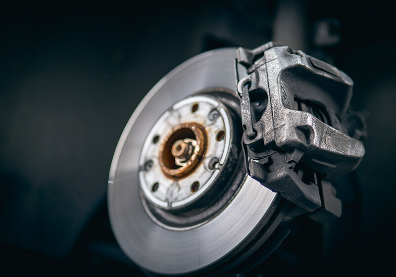 Nahaufnahme einer sauberen und glänzenden Autoscheibenbremse mit Bremssattel.