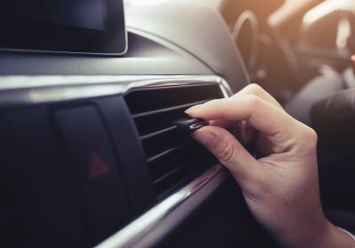 Hand reguliert Klimaanlage im Auto